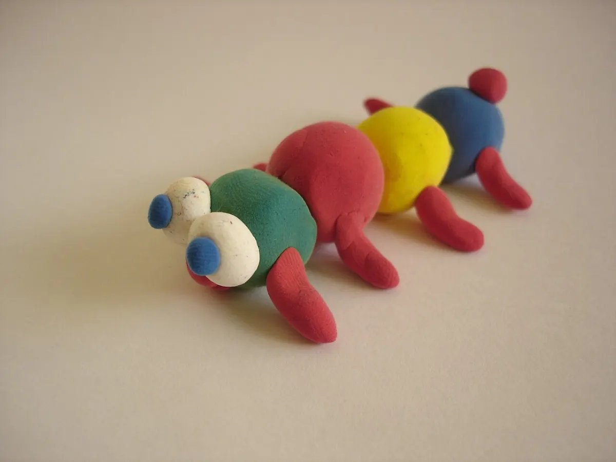 Lagarta colorida modelada com massinha sobre uma mesa clara